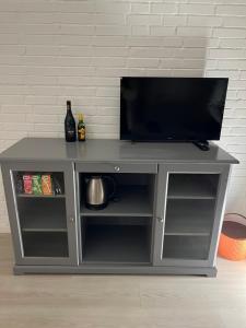 a gray entertainment stand with a television on top at Bed House By Me 2 in Vester-Skerninge