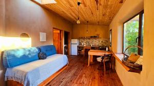 Cet appartement comprend une chambre avec un lit et une cuisine avec une table. dans l'établissement Citrino - Alojamiento Responsable en la naturaleza, à Bella Vista