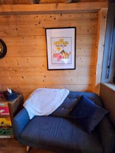 a blue couch in a room with a picture on the wall at Studio type chalet in Gérardmer
