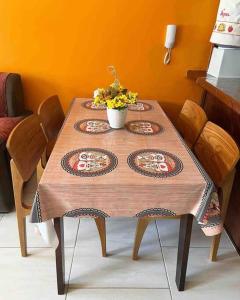 een houten tafel met vier platen erop bij Casa em frente a Praia das Dunas, Cabo Frio - RJ in Cabo Frio