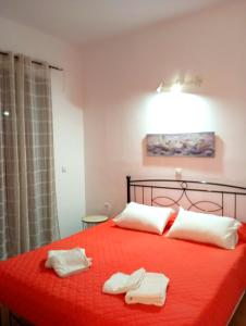 a bedroom with a red bed with two towels on it at Villa Stella Family House in Pefki