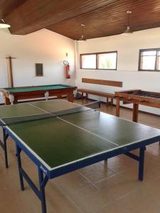 een kamer met een tafeltennistafel en 2 tafels bij Casa em frente a Praia das Dunas, Cabo Frio - RJ in Cabo Frio