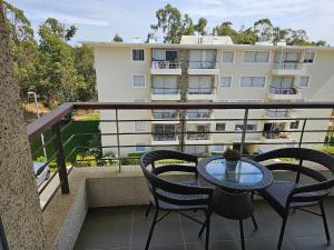 a balcony with a table and chairs and a building at Depto Parque Mar El Tabo in El Tabo