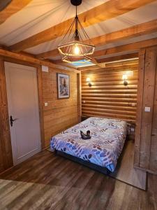 ein Schlafzimmer mit einem Bett in einer Holzhütte in der Unterkunft Studio type chalet in Gérardmer
