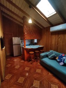 a living room with a couch and a kitchen at Cabaña la Araucaria in El Manzano