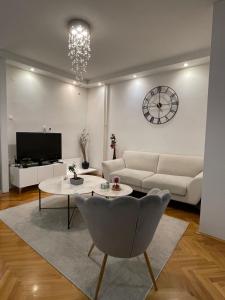 a living room with a couch and a table and a clock at Luxury Getaway Apartment in Skopje