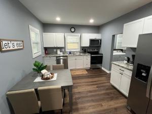 eine Küche mit weißen Schränken und einem Tisch mit Stühlen in der Unterkunft Mid Century 1/4 mile to Downtown Main Street - breweries, coffee, dining, shops in Monroe