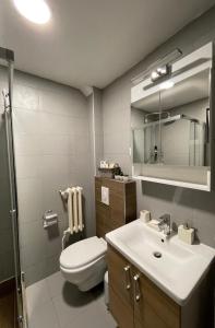 a bathroom with a toilet and a sink and a mirror at Luxury Getaway Apartment in Skopje