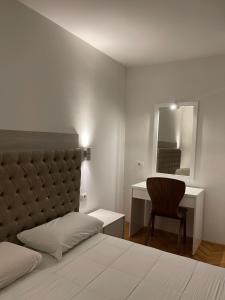 a bedroom with a bed and a desk and a chair at Luxury Getaway Apartment in Skopje