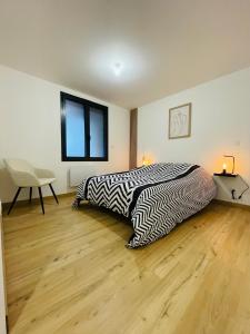 a bedroom with two beds and a table and a chair at Charmant T3 des Pyrénées in Argelès-Gazost