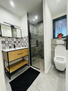 a bathroom with a toilet and a glass shower at Charmant T3 des Pyrénées in Argelès-Gazost