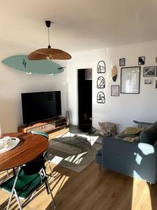 sala de estar con sofá, mesa y TV en Lumineux et calme avec terrasse - parking gratuit, en Montpellier
