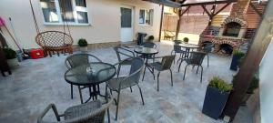 a patio with tables and chairs and a fireplace at Vila Adelin in Tăşnad