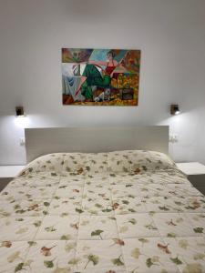 Ce lit se trouve dans une chambre ornée d'une peinture murale. dans l'établissement Sanja apartments Sveti Servul, à Novigrad