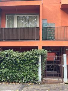 an orange building with a gate and a hedge at Casa Clima di fronte al parco in Bologna