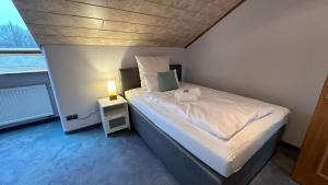 a bedroom with a bed and a lamp on a night stand at Apartment Oase 2, Parkplatz, Küche, Internet in Klosterlechfeld