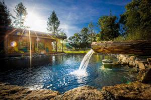 a pool with a waterfall in the middle of a yard at Holiday Raj in Bešeňová