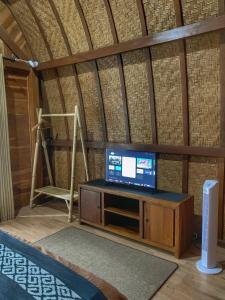 een woonkamer met een tv in een kamer bij Besakih Homestay & Villa in Besakih