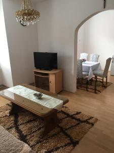 - un salon avec une télévision, une table et un canapé dans l'établissement Apartman Marija, à Kupres