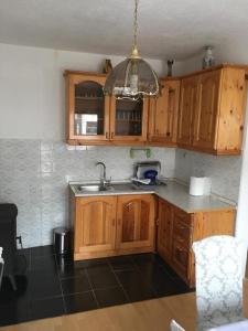 - une cuisine avec des placards en bois et un évier dans l'établissement Apartman Marija, à Kupres