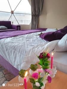 a bedroom with a bed with candles and flowers on a table at wadi rum caeser camp in Wadi Rum
