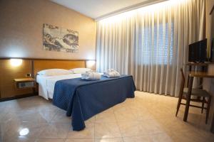 Una habitación de hotel con una cama y una mesa con toallas en Antum Hotel, en Benevento