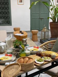 einen Tisch mit Teller mit Lebensmitteln drauf in der Unterkunft Riad Villa Wengé & Spa in Marrakesch