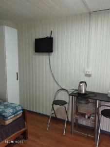 um quarto com uma mesa e uma televisão na parede em Cabañas Janico em Loncoche
