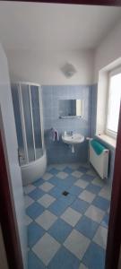 baño azul y blanco con lavabo y espejo en Ubytování Na Stráni, en Jablonec nad Nisou