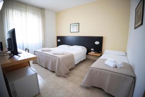 ein Hotelzimmer mit 2 Betten und einem TV in der Unterkunft Antum Hotel in Benevento