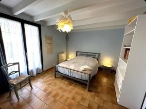 a bedroom with a bed and a chair and windows at La bergerie des Landes in Lit-et-Mixe +74 photos