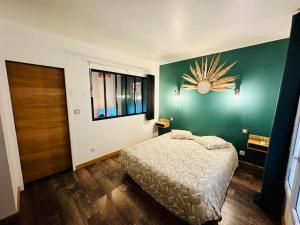 a bedroom with a bed and a green wall at Appartement Cosy in Perpignan