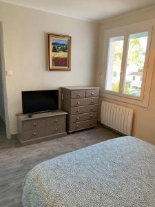 1 dormitorio con 1 cama y vestidor con TV en Appartement T3 - 70m² - L'Espérance, en La Seyne-sur-Mer