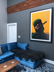ein Wohnzimmer mit einer blauen Couch und einem Bild eines Rauchers in der Unterkunft Petaluma Warehouse Lofts, Unit B in Petaluma