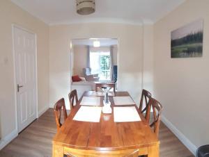 comedor con mesa de madera y sillas en 3 Bedroom 3 Bathroom House, Dublin, en Lucan