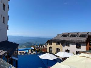 a view of a pool with umbrellas and a building at Milmari Premier 28 Kopaonik in Kopaonik