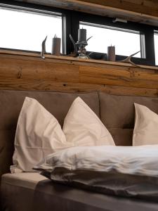a bed with white pillows in front of a window at Peer Alm in Navis
