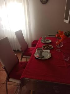 una mesa roja con dos platos de comida. en Appartamento sul Naviglio, alle porte di Milano, en Corsico