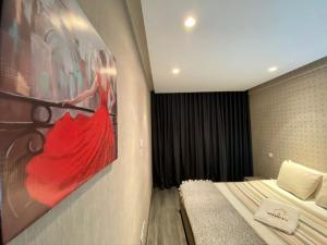 a bedroom with a painting of a woman in a red dress at Studio ALMASSIRA in Casablanca