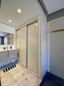 a bathroom with a walk in shower and a sliding door at Studio ALMASSIRA in Casablanca