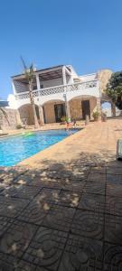 une maison avec une piscine à côté d'un bâtiment dans l'établissement Casa Kassi, à Ndéyane