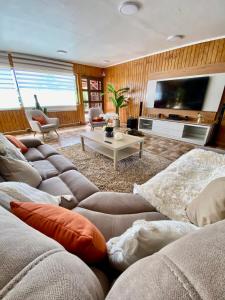 sala de estar con sofás y TV de pantalla plana. en Alojamiento RBOY Las Mariposas, en Chillán
