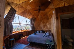 a bedroom with a bed in a wooden ceiling at Huiro Lodge in Puerto Corral