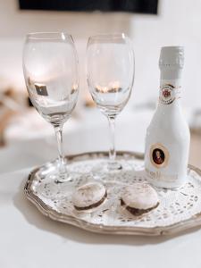 two glasses and a bottle of wine on a plate at Neue, attraktive Wohlfühlwohnung mit traumhafter Aussicht in Neubulach