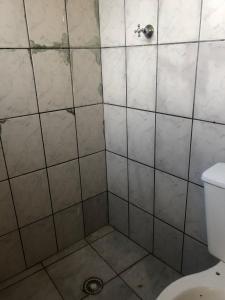 a bathroom with a tiled shower with a toilet at Camping beira mar in Bertioga