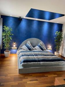 a bed in a room with a blue wall at Haus Respirada NRW mit großem Wellnessbereich, Gym in Meckenheim