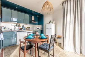 een keuken met een tafel, stoelen en een koelkast bij La maison de Vallières in Clermont-Ferrand +9 foto's