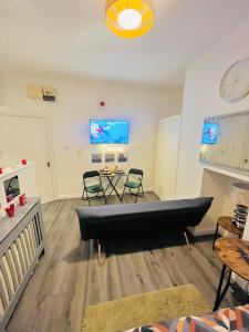 een woonkamer met een bank en een tafel bij Studio flat in Shipley Central in Shipley