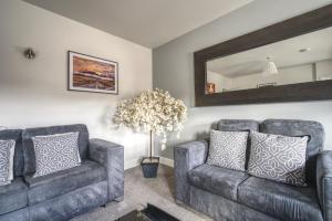 a living room with two couches and a mirror at #St Georges Court by DerBnB, Spacious 2 Bedroom Apartments, Free Parking, WI-FI, Netflix & Within Walking Distance Of The City Centre in Derby