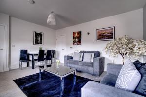 a living room with a couch and a table at #St Georges Court by DerBnB, Spacious 2 Bedroom Apartments, Free Parking, WI-FI, Netflix & Within Walking Distance Of The City Centre in Derby